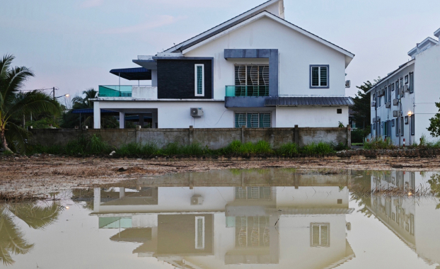 A house partially submerged in water, illustrating flood risk and claims statistic.